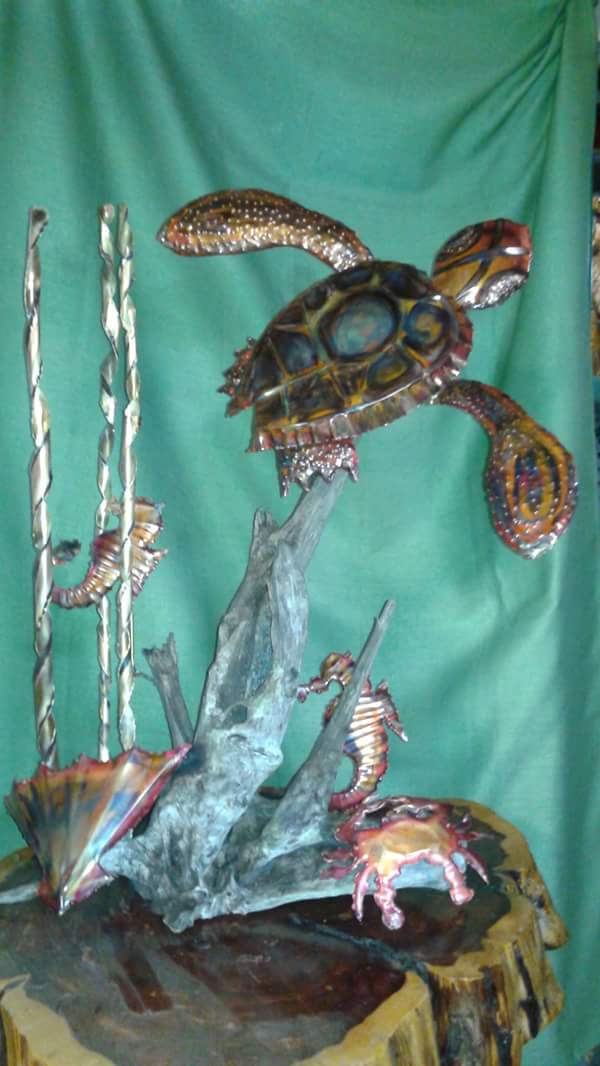 A sculpture of an ocean scene with a sea horse, crab and turtle